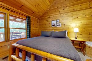 een slaapkamer met een bed in een blokhut bij Moose Tracks Lodge in Pigeon Forge