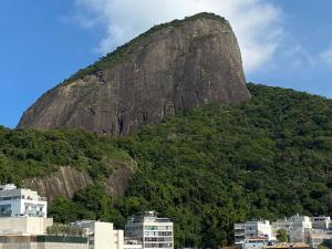 a mountain in the middle of a city with buildings at Apto com visita mar, piscina, sauna, academia e serviço de limpeza in Rio de Janeiro