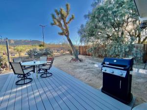 un barbecue e un tavolo con sedie su una terrazza di Float Pool, Hot Tub, Sauna, Firepit, BBQ, Telescope, Views, EV Chg, a Joshua Tree