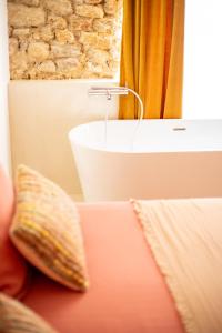 un bagno con lavandino e un divano con cuscino di La Maison des Lamanon a Salon-de-Provence