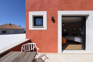 a balcony with a wooden table and a television on a building at Campo Di Fiori, Maisons de Charme in Calvi