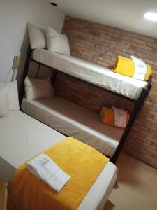 a room with two bunk beds and a brick wall at Hotel Torreon De Rionegro in Rionegro