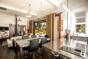 cocina y sala de estar con mesa y sillas en The Factory Luxury Accomodation en Kaikoura