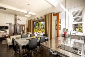 cocina y sala de estar con mesa y sillas en The Factory Luxury Accomodation, en Kaikoura