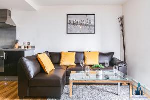 City View Apartments في برمنغهام: غرفة معيشة مع أريكة جلدية وطاولة قهوة