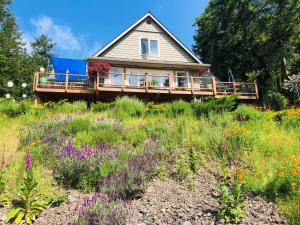 a house on a hill with a field of flowers at Ocean Mist Getaway(OMG) in Eastsound