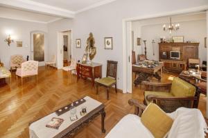 Vintage apartment KOLONAKI في أثينا: غرفة معيشة مليئة بالأثاث على أرضية خشبية