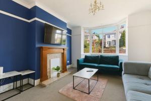 een woonkamer met een bank en een open haard bij Semi-Detached House Featuring a Mezzanine Level in Nether Edge