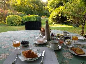 - une table avec petit-déjeuner composé de croissants et de jus d'orange dans l'établissement Villa de Miha, à Valbonne