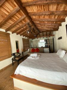 a bedroom with a large bed with wooden ceilings at Oak Tree house in Guatapé
