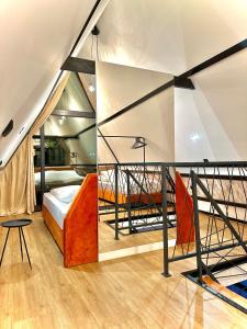 - une chambre mansardée avec un lit et un balcon dans l'établissement MANGATA, à Pale