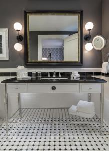 a bathroom with a sink and a mirror at Le Meridien Dallas, The Stoneleigh in Dallas