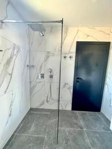 a bathroom with a shower with a glass door at MANGATA in Pale +49 photos