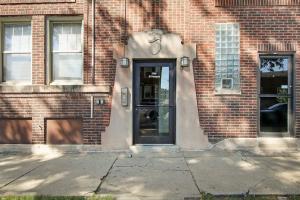 een deur naar een bakstenen gebouw met een bord erop bij Comfy and Serene Studio Apt in Chicago - Pensacola 2W in Chicago