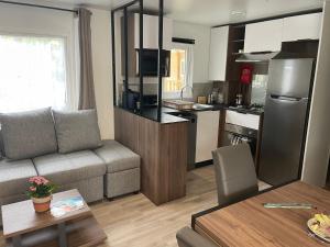 a living room and kitchen with a couch and a table at A la brise du Ferret - Camping les Embruns in Lège-Cap-Ferret