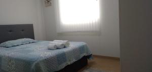 1 dormitorio con 1 cama con 2 toallas en Victoria Costa Verde, en Lima