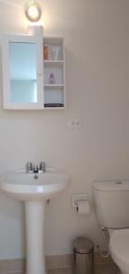 een witte badkamer met een wastafel en een toilet bij Victoria Costa Verde in Lima