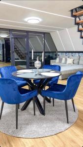 jadalnia ze stołem i niebieskimi krzesłami w obiekcie MANGATA w mieście Pale