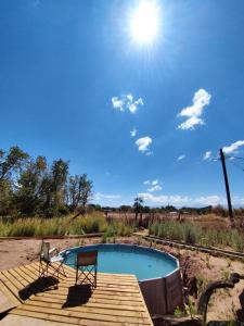 una piscina con 2 sillas en una terraza de madera en SURI ATACAMA - Eco H&T en San Pedro de Atacama