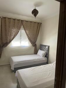 1 dormitorio con 2 camas y ventana en Jardin hay chrifia, en Marrakech