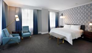a hotel room with a bed and two chairs at Le Meridien Dallas, The Stoneleigh in Dallas