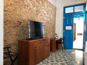een woonkamer met een televisie op een houten kast bij Casita de la 12 5 min a centro Campeche ideal para 2 ó 3 personas Cocina con estufa de inducción, microondas y refrigerador in Campeche