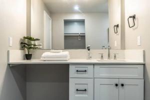 a white bathroom with a sink and a mirror at Roomy Urban Apartment Montrose! Free Parking #8 in Houston