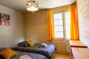 um quarto com duas camas e uma janela em Gîte Chez Pierrot - La vallée des châteaux em La Roque-Gageac