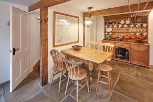 ein Esszimmer mit einem Holztisch und Stühlen in der Unterkunft Stunning 3 bed Yorkshire Dales cottage in Appletreewick