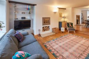 a living room with a blue couch and a fireplace at Stunning 3 bed Yorkshire Dales cottage in Appletreewick
