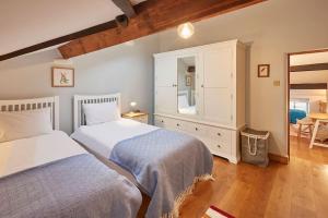 a bedroom with two beds and a dresser and a mirror at Stunning 3 bed Yorkshire Dales cottage in Appletreewick