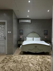 ein Schlafzimmer mit einem großen Bett und einem Teppich in der Unterkunft Princess Farmhouse in Al Ḩamīdīyah
