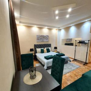 - une chambre avec un lit, une table et des chaises dans l'établissement Emerald Apartment Belgrade, à Senjak (historical)
