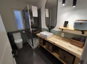 a bathroom with a sink and a toilet and a mirror at Lindo pisito in León