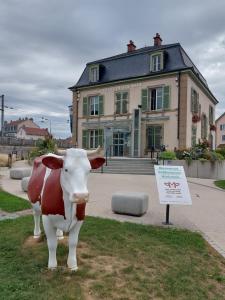 una estatua de una vaca delante de un edificio en Appart' DuChatelain lumineux, vue sur château en Montbéliard