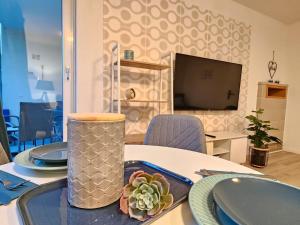 una mesa con platos y un jarrón encima en Blu Apartment Ferienwohnung, Businesswohnung, Monteurzimmer, en Salzgitter