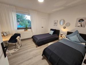 1 dormitorio con 2 camas y ventana en Blu Apartment Ferienwohnung, Businesswohnung, Monteurzimmer, en Salzgitter