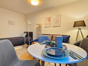 - un salon avec une table, des chaises et un canapé dans l'établissement Blu Apartment Ferienwohnung, Businesswohnung, Monteurzimmer, à Salzgitter