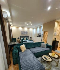 a living room with a green couch and a table at Emerald Apartment Belgrade in Senjak (historical)