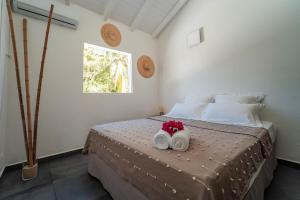 a bedroom with a bed with two towels and a window at La Petite Caravelle Guadeloupe in Sainte-Anne