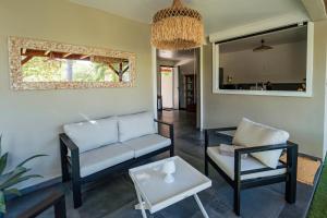 ein Wohnzimmer mit einem Sofa und einem Tisch in der Unterkunft La Petite Caravelle Guadeloupe in Sainte-Anne