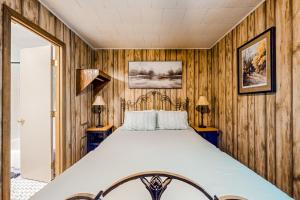 a bed in a room with wooden walls at White Pine Perch in Clayton