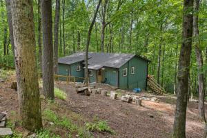 a green cabin in the middle of the woods at White Pine Perch in Clayton