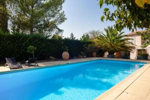 a swimming pool with two chairs in a yard at Cocon avec piscine et jardin in Marseille