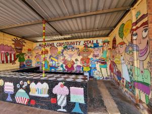 una pared con un mural de gente en ella en Everlasting Guesthouse Morowa, 