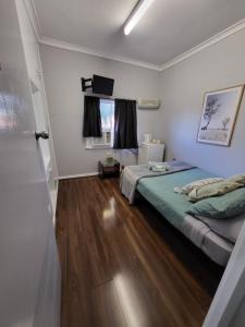a bedroom with two beds and a television in it at Everlasting Guesthouse Morowa in Morawa