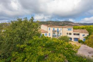 een groot gebouw met blauwe ramen in een tuin bij Appartement Le Plan de La Tour in Plan-de-la-Tour
