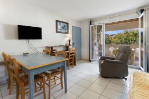 een woonkamer met een tafel en stoelen en een eetkamer bij Appartement Le Plan de La Tour in Plan-de-la-Tour
