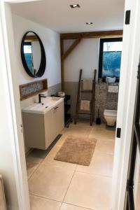 uma casa de banho com um lavatório, um espelho e um WC. em B&B Oak em Velden