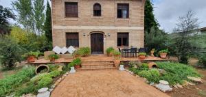 a brick house with a staircase in front of it at Aljubea, tu casa rural en Cordoba in Córdoba